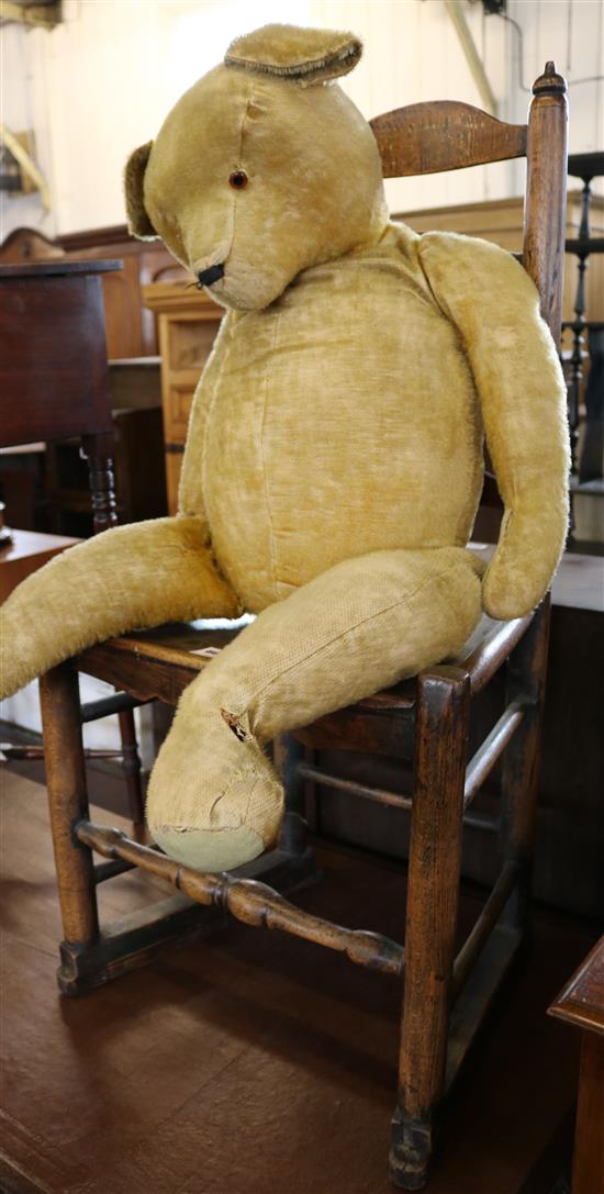 An early 20th century gold plush teddy bear and chair (-)